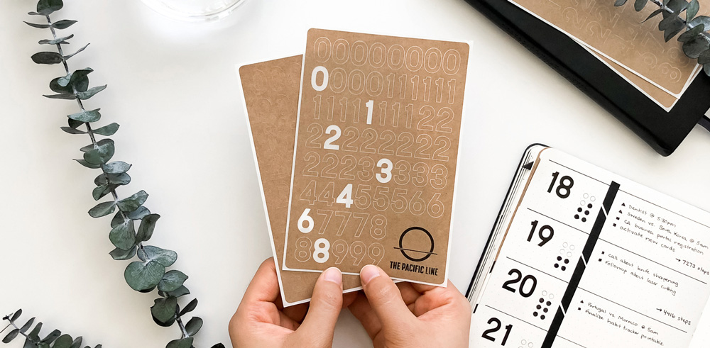 Kraft paper journal number stickers being held in a woman's hands
